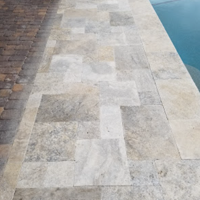 Travertine pool coping installed around a Las Vegas backyard pool edge